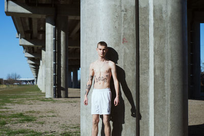 Full length of young woman standing against wall