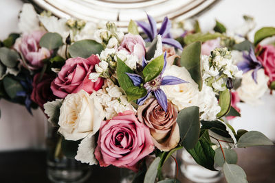 Close up of bridal wedding bouquet - pink peonies, rabbit ear plant, white hydrangea, purple lilies.