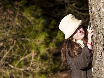 Woman embracing tree trunk