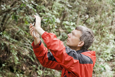 Side view of mature man photographing in park