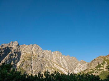Scenic view of rocky mountains against clear blue sky