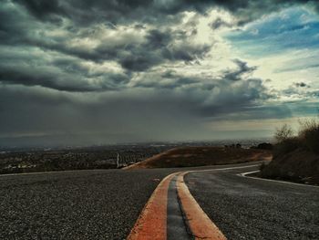 View of empty road against cloudy sky