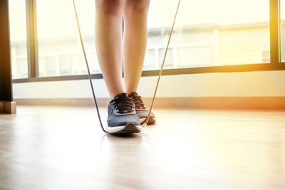 Low section of woman wearing shoes on floor