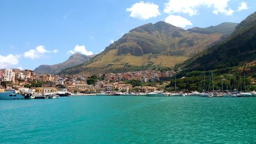 Scenic view of sea by buildings against sky