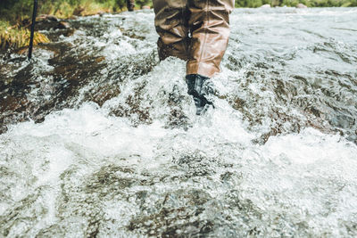 Low section of man standing in water