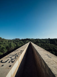 Empty road against clear blue sky