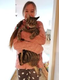 Full length of woman holding cat at home