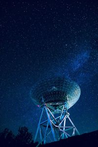 Low angle view of satellite dish against star field