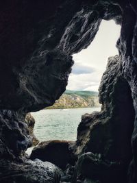 Rock formations by sea against sky