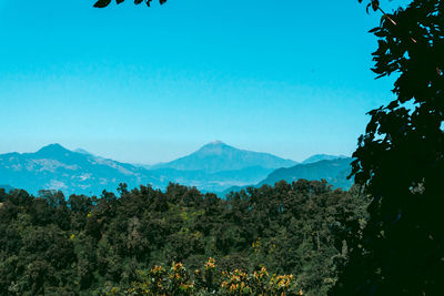 Scenic view of mountains against blue sky