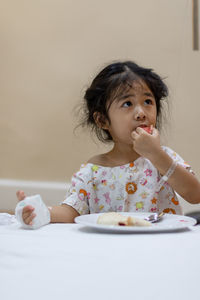 Cute girl eating food at home