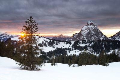 Scenic view of snowcapped mountains against sky during sunset