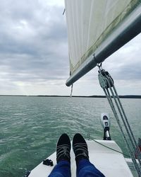 Low section of person in sea against sky