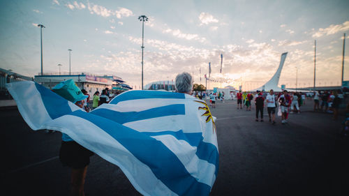 People on street against sky during sunset