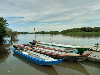 Boat moored in lake against sky