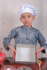 Portrait of boy preparing food in kitchen