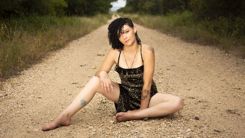 Young woman sitting on sand at beach