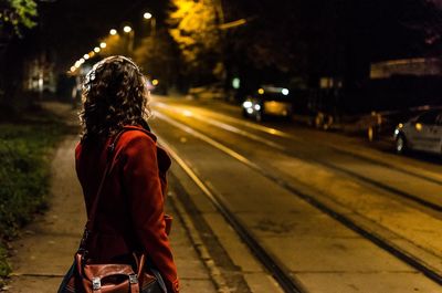 Woman waiting on street at night