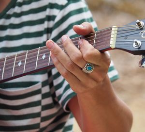 Midsection of man playing guitar