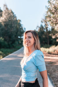 Portrait of smiling young woman on road