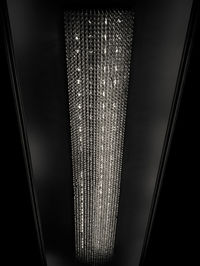 Close-up of illuminated light bulb hanging at window