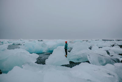 People standing on snowcapped mountain against sky