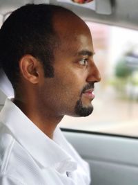 Side view of young man in car