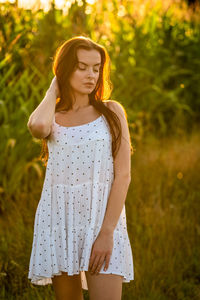 Young woman standing against plants