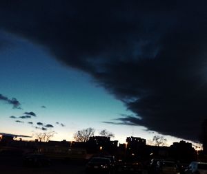 Cars on road against cloudy sky