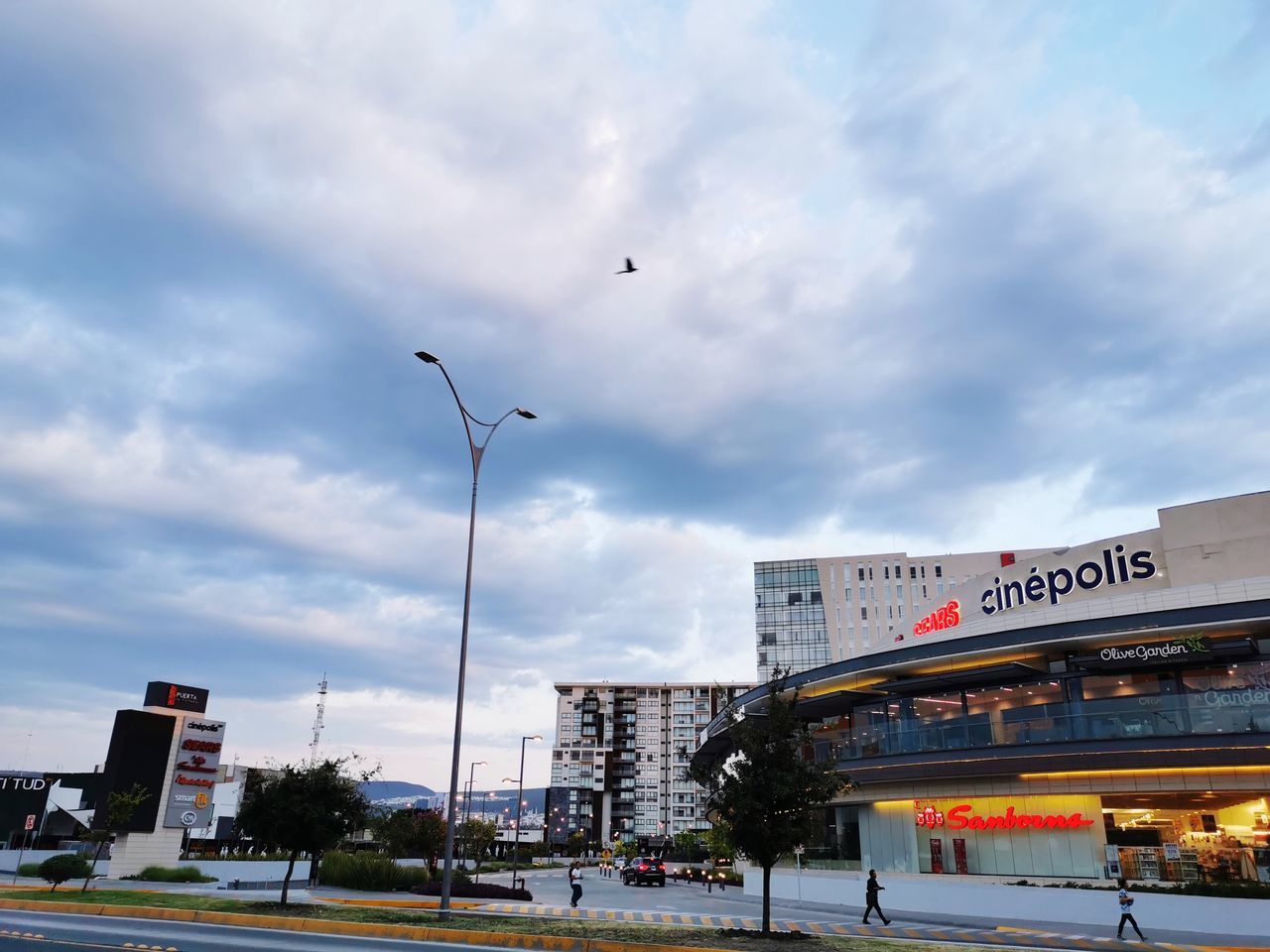 STREET LIGHTS ON ROAD IN CITY AGAINST SKY