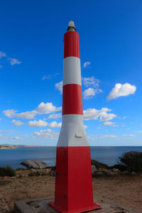 Lighthouse by sea against sky