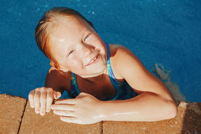 High angle view of smiling girl in swimming pool