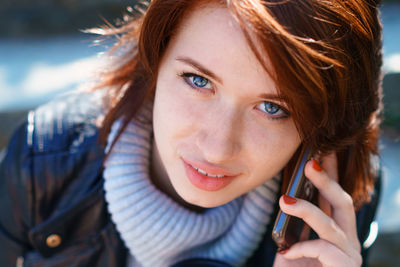 Portrait of young woman using mobile phone outdoors