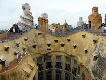 Low angle view of statues on building against sky