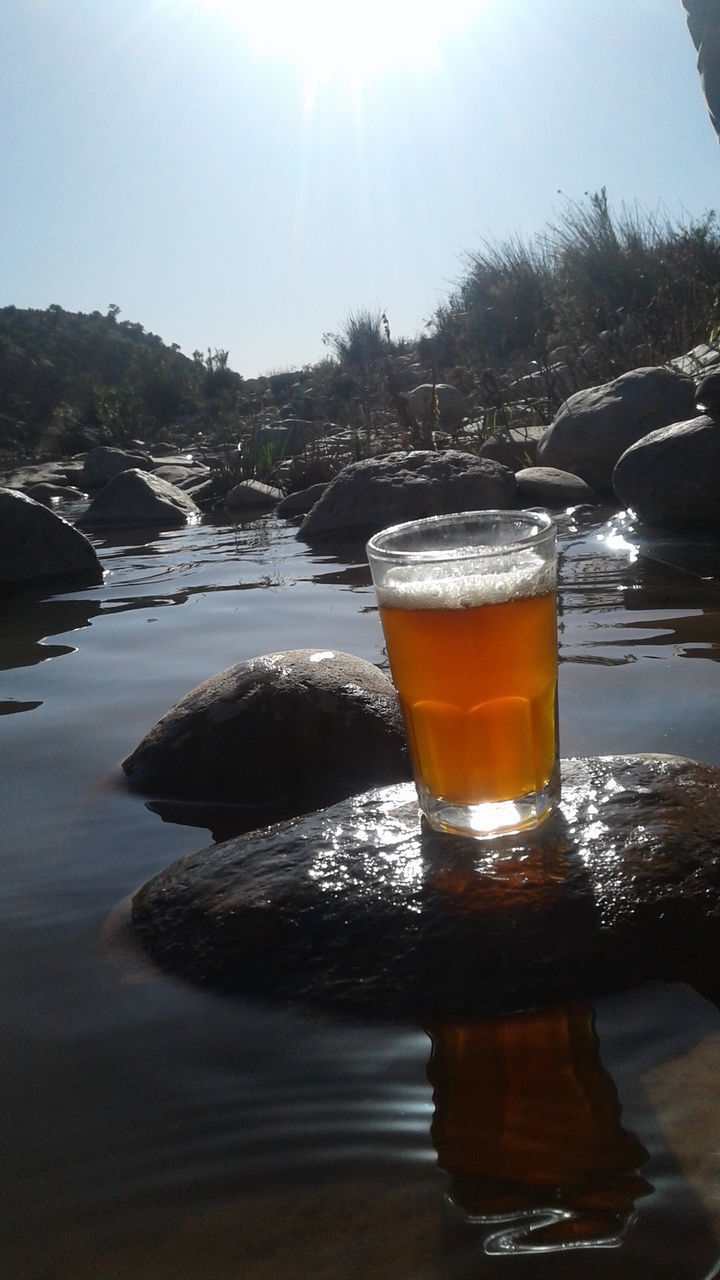 CLOSE-UP OF BEER GLASS AGAINST SKY