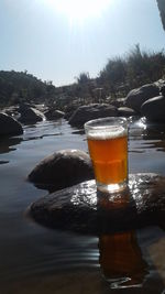 Close-up of beer in glass against water