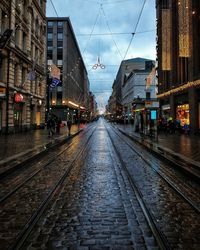 Railroad tracks amidst buildings in city against sky