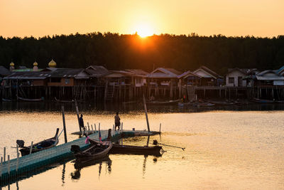 Scenic view of fisherman village near sea against sky during sunset