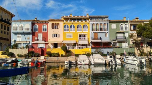 Boats moored in lake against buildings in city