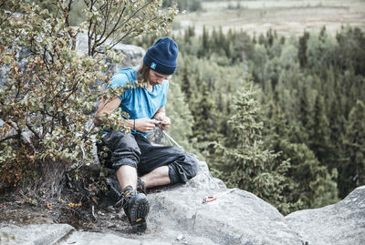 Man sitting on rock in forest