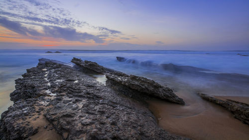 High angle view of rock formations at beach during sunset