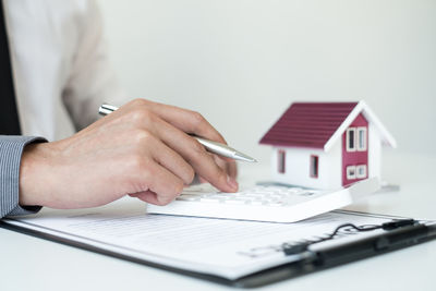 Midsection of woman holding umbrella in house