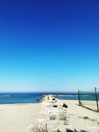 Scenic view of beach against clear blue sky