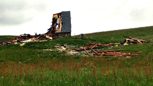 Old ruins of building on field against sky