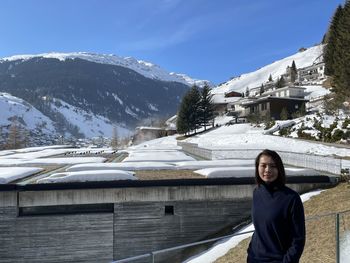 Portrait of young woman standing against mountain