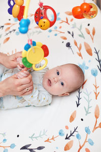 High angle view of baby boy with toy on table