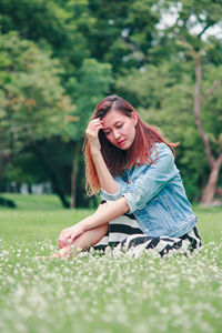 Young woman sitting on field