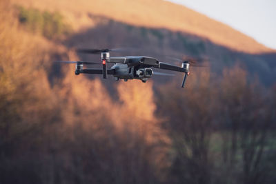 Low-angle view of a professional camera drone/quadrocopter at sunset