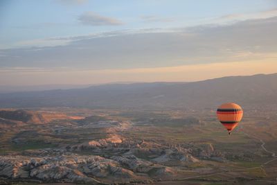 Hot air balloon flying over landscape against sky