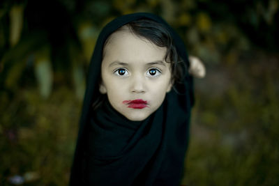 Portrait of cute girl wearing smudged lipstick in forest